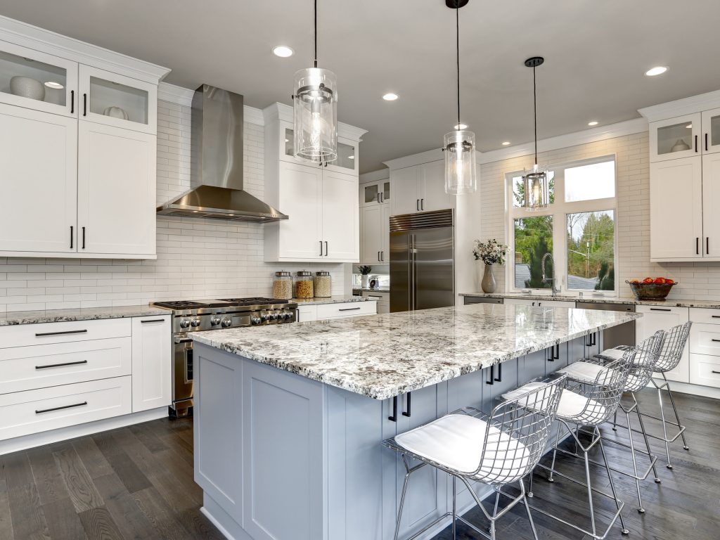 Beautiful kitchen in luxury home interior with island and stainless steel chairs