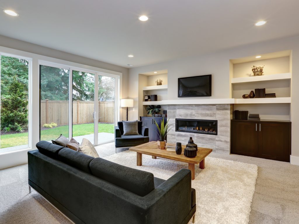 Beautiful modern living room interior with stone wall and fireplace in luxury home